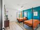 Charming bedroom with a blue accent wall, twin beds, and a ceiling fan at 14000 Lugano Ct, Hudson, FL 34669