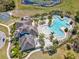An aerial view showcasing a community center and pool with tropical landscaping and comfortable lounge chairs at 14000 Lugano Ct, Hudson, FL 34669