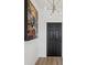 Entryway with modern art and light fixture and a dark front door with wood floors at 14000 Lugano Ct, Hudson, FL 34669