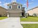 Two-story home featuring a two-car garage, manicured lawn, and a welcoming front entrance with an American flag at 14000 Lugano Ct, Hudson, FL 34669