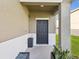 Inviting covered front porch featuring a black door and sleek potted plants at 14000 Lugano Ct, Hudson, FL 34669