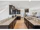 Kitchen featuring dark cabinets, granite counters, stainless steel appliances, and wood flooring at 14000 Lugano Ct, Hudson, FL 34669