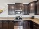 Modern kitchen features stainless steel appliances, granite countertops, and dark wood cabinets at 14000 Lugano Ct, Hudson, FL 34669