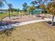 Community playground featuring swings, a slide, and climbing structures, surrounded by green space and trees at 14000 Lugano Ct, Hudson, FL 34669