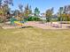 A colorful community playground surrounded by green grass and trees near homes at 14000 Lugano Ct, Hudson, FL 34669