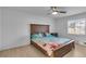 Bedroom with natural light featuring a ceiling fan and a wood-framed bed with stylish bedding at 15950 Adobe Dr, Hudson, FL 34667