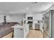 White kitchen with island and stainless steel appliances open to living room at 15950 Adobe Dr, Hudson, FL 34667