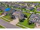 Aerial view of a residential neighborhood with well-maintained lawns, mature trees, and a tranquil pond at 18558 Cortes Creek Blvd, Spring Hill, FL 34610