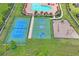 Aerial view of community tennis court, basketball court, playground, and swimming pool with sunbathing chairs at 18558 Cortes Creek Blvd, Spring Hill, FL 34610