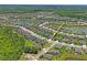Aerial view of a community showcasing well-maintained homes near a lake, offering a serene and picturesque setting at 18558 Cortes Creek Blvd, Spring Hill, FL 34610
