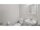 Bathroom featuring white fixtures, including toilet, sink with mirror, and soft neutral paint at 18558 Cortes Creek Blvd, Spring Hill, FL 34610