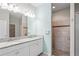Bathroom with double sink vanity, granite countertops, and a tiled walk-in shower at 18558 Cortes Creek Blvd, Spring Hill, FL 34610