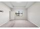 Spacious bedroom with plush carpet, a tray ceiling, and a bright window at 18558 Cortes Creek Blvd, Spring Hill, FL 34610