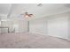 Spacious carpeted bonus room with white trim, ceiling fan, and staircase at 18558 Cortes Creek Blvd, Spring Hill, FL 34610