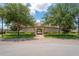 A clubhouse entrance framed by trees and manicured landscaping, creating an inviting first impression at 18558 Cortes Creek Blvd, Spring Hill, FL 34610