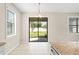 Dining area with natural light, sliding glass door to backyard, and granite countertop extending from kitchen island at 18558 Cortes Creek Blvd, Spring Hill, FL 34610