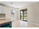Dining area with sliding glass door to the backyard and an eat-in kitchen area, filled with natural light at 18558 Cortes Creek Blvd, Spring Hill, FL 34610
