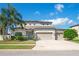 Charming two-story home with three-car garage, landscaped yard and a beautiful palm tree at 18558 Cortes Creek Blvd, Spring Hill, FL 34610
