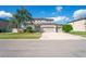 Charming two-story home with three-car garage, landscaped yard and a beautiful palm tree at 18558 Cortes Creek Blvd, Spring Hill, FL 34610