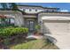 Close up of a charming two-story home featuring a manicured lawn and well-lit entryway at 18558 Cortes Creek Blvd, Spring Hill, FL 34610