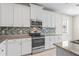 Kitchen area showcasing white cabinets, stainless steel appliances, granite counters, and tile backsplash at 18558 Cortes Creek Blvd, Spring Hill, FL 34610