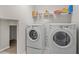 Laundry room featuring modern appliances, storage shelves, and easy access to storage at 18558 Cortes Creek Blvd, Spring Hill, FL 34610