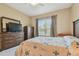 Comfortable bedroom featuring a dresser with TV and a bright, sunny window at 20820 Amanda Oak Ct, Land O Lakes, FL 34638