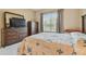 Comfortable bedroom featuring a dresser with TV and a bright, sunny window at 20820 Amanda Oak Ct, Land O Lakes, FL 34638