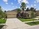 Attractive single-story home with a three-car garage, stone detailing, and lush, green lawn at 20820 Amanda Oak Ct, Land O Lakes, FL 34638