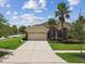Front view of the house features manicured lawn, palm trees, and a two-car garage at 20820 Amanda Oak Ct, Land O Lakes, FL 34638