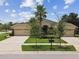 Beautiful single-story home with a three-car garage, stone accents, and meticulously maintained landscaping at 20820 Amanda Oak Ct, Land O Lakes, FL 34638