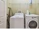 Laundry room features modern washer, dryer, and built-in shelving at 20820 Amanda Oak Ct, Land O Lakes, FL 34638