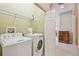 Well-organized laundry area with shelving and modern washer and dryer appliances for convenient chores at 20820 Amanda Oak Ct, Land O Lakes, FL 34638