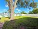 Large backyard features healthy grass, mature trees and a tall, white privacy fence at 2141 Holiday Dr, Holiday, FL 34691