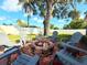Backyard seating area with brick-lined fire pit and chairs, perfect for outdoor entertaining at 2141 Holiday Dr, Holiday, FL 34691