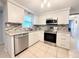 Modern kitchen boasts stainless steel appliances, granite countertops, and sleek white cabinets at 2141 Holiday Dr, Holiday, FL 34691