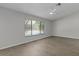 Spacious bedroom with wood-look flooring and a large window overlooking the pool at 2152 Danforth Rd, Spring Hill, FL 34608