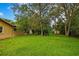 Expansive backyard featuring lush lawn, mature trees, and storage shed, offering ample space for outdoor enjoyment at 2169 Danforth Rd, Spring Hill, FL 34608