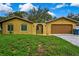 Cozy single-story home featuring a two-car garage, gated entrance, and bright yellow stucco at 2169 Danforth Rd, Spring Hill, FL 34608