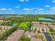 Scenic aerial view of a well-maintained residential community surrounded by lush greenery and a serene lake at 2209 Kings Palace Dr # 21-204, Riverview, FL 33578