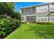 Lush backyard view showcasing the screened-in patio and manicured lawn in a serene setting at 2209 Kings Palace Dr # 21-204, Riverview, FL 33578