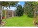 Lush backyard featuring a well-maintained lawn, mature trees, and a screened-in patio at 23302 Lucerne Pl, Land O Lakes, FL 34639