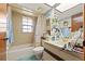 Bathroom with a tub and shower, neutral tile, and window with natural light at 23302 Lucerne Pl, Land O Lakes, FL 34639