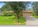 Home featuring mature landscaping, a spacious lawn, and a two-car garage and long driveway at 23302 Lucerne Pl, Land O Lakes, FL 34639