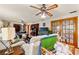 Cozy living room featuring a ceiling fan, wood-trimmed sliding glass doors, and comfortable seating at 23302 Lucerne Pl, Land O Lakes, FL 34639