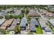 Aerial view of a neighborhood with well-maintained houses, lush green trees, and a gray asphalt road at 3450 Ferrell St, New Port Richey, FL 34655