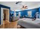 This bedroom showcases blue walls, a ceiling fan, and a cozy sitting area, creating a versatile space at 3450 Ferrell St, New Port Richey, FL 34655
