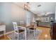Open dining area features a modern chandelier and wood floors that seamlessly flow into the adjacent living space at 3450 Ferrell St, New Port Richey, FL 34655