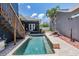 Backyard view of pool, palm trees, patio furniture, and privacy fence at 3450 Ferrell St, New Port Richey, FL 34655