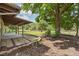 Spacious backyard with patio under the roofline with mature trees and partial fencing at 34577 Orchid Pkwy, Dade City, FL 33523